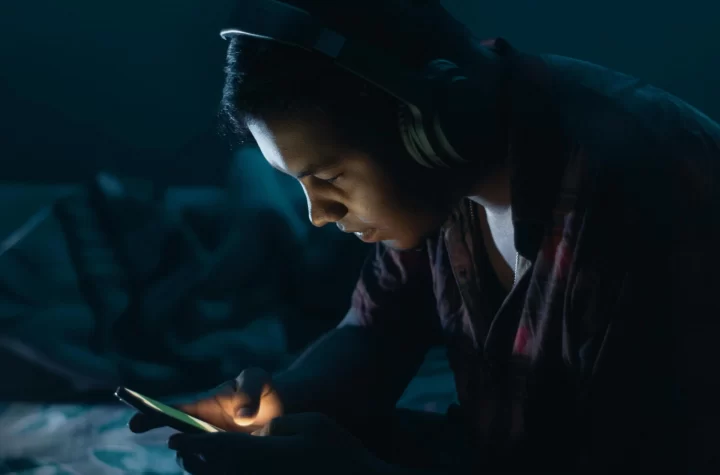 Child looking at mobile phone in the dark