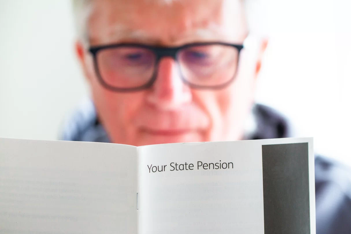 man with glasses reading pension information