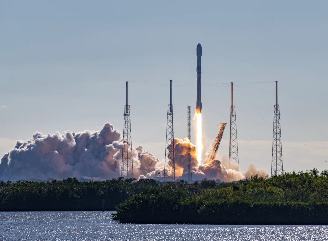 SpaceX Falcon 9 rocket and satellite payload launch in Florida. Booster are re-usable and either land at Cape Canaveral or on a barge at sea. Towers surrounding the launch pad are lightning arrestors. Merritt Island National Wildlife Refuge, Florida, USA 01/03/2023